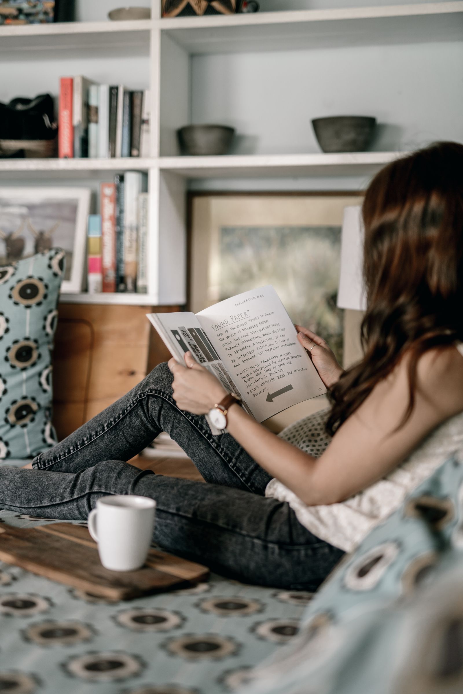 Woman relaxing at home with a book and things she already owns