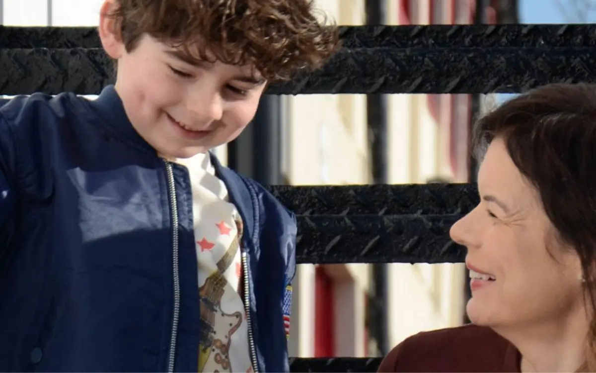 Boy smiling beside an adult at All Things Dylan