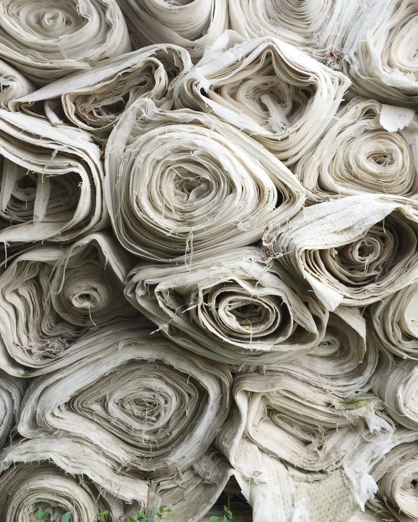 Rolls of natural undyed textile in soft neutral tones